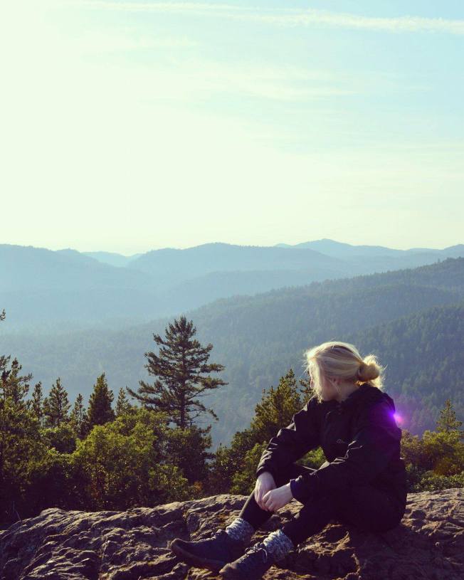 A rocky outcrop overlooking green hills